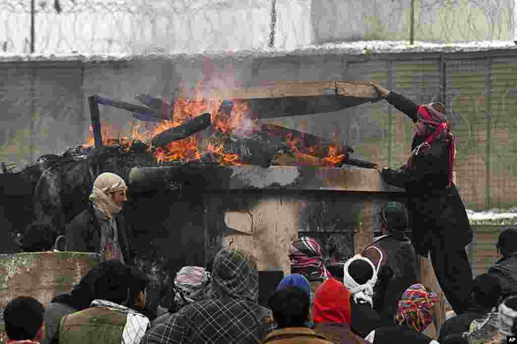 Afghan men stand near tires set on fire during a protest outside the U.S. military base in Bagram, north of Kabul February 21, 2012. (REUTERS)