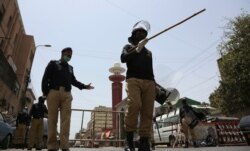 Police officers stand guard outside a mosque during a nationwide lockdown as a preventive measure against the outbreak of coronavirus, in Karachi, Pakistan, April 24, 2020.