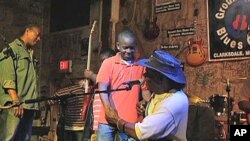 Bluesman Bill 'Howlin Mad' Perry congratulates one of his blues musician students after a set of tunes on stage at the Delta Blues Museum, Nov 2010