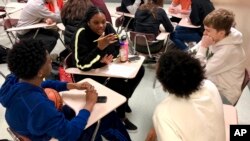 Sophomore Ramaya Wright, 15, second from left, leads a group making a list of the characteristics of an abusive relationship, during a class at Central Catholic High School in Portland, Ore., on April 15, 2019. (AP Photo/Gillian Flaccus)