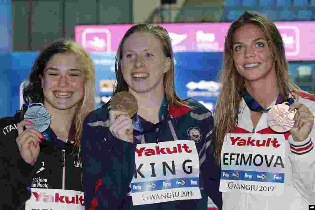 لیلی کینگ دختر ۲۲ ساله آمریکایی (وسط) قهرمانی خود را در مسابقات شنای قهرمانی جهان در کره جنوبی جشن می&zwnj;گیرد. در رشته پنجاه متر کرال سینه، بعد از این ورزشکار آمریکایی، ورزشکاران ایتالیا (چپ) و روسیه دوم و سوم شدند.