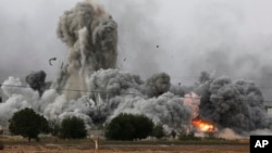 Thick smoke, debris and fire rise following an airstrike by the U.S.-led coalition in Kobani, Syria, as seen from Mursitpinar, on the outskirts of Suruc, at the Turkey-Syria border, Oct. 12, 2014. 