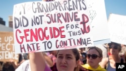 Danielle Nanni holds up a sign while listening to speakers during a rally against hate in Berkeley, Calif., Aug. 27, 2017.