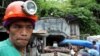 FILE - A mine worker watches the ongoing recovery operation after an explosion inside the tunnel in a collapsed gold mine in Mt. Diwata in Compostela Valley province, Philippines.