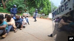 Un policier monte la garde pendant que certaines des personnes arrêtées lors de manifestations sur la hausse du prix de l'essence comparaissent devant le tribunal d'instance de Harare, le 16 janvier 2019.