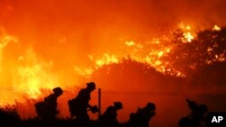 Firefighters battle the Saddleridge fire in Sylmar, Calif., Oct. 11, 2019.