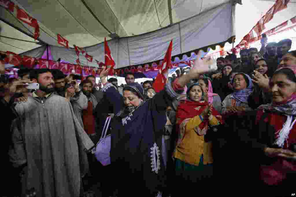 A Kashmiri woman activist of the ruling National Conference party dances during an election rally on the outskirts of Srinagar, India, April 7, 2014. 