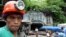 FILE - A mine worker watches the ongoing recovery operation after an explosion inside the tunnel in a collapsed gold mine in Mt. Diwata in Compostela Valley province, Philippines.