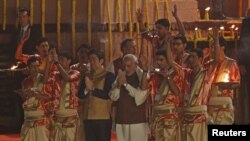 Japan's Prime Minister Shinzo Abe (front, 3rd L) and his Indian counterpart Narendra Modi perform a religious ritual during evening prayers on the banks of the river Ganges in Varanasi, India, December 12, 2015.