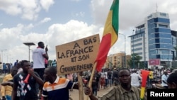 Opposition supporters react to the news of a possible mutiny of soldiers in the military base in Kati, outside the capital Bamako, at Independence Square in Bamako, Mali, Aug. 18, 2020. 