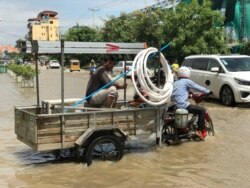 Drivers travel through a flooded street following recent rains in Phnom Penh, Cambodia, October 12, 2020. (Hul Reaksmey/VOA Khmer)