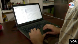 Captura de pantalla de un trabajador frente a una computadora. [Video de Oscar Ortiz, VOA]