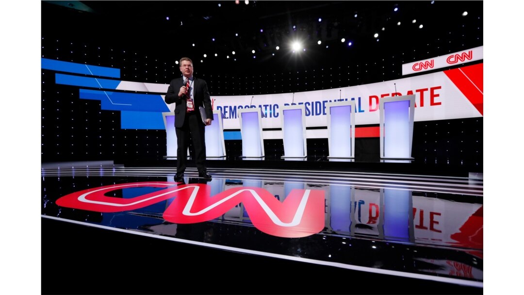 A CNN employee stands on the stage, Jan. 14, 2020, before a Democratic presidential primary debate hosted by CNN and the Des Moines Register in Des Moines, Iowa.