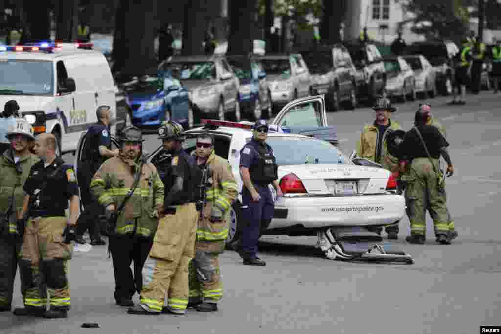 Emergency personnel stand near a police car after gunshots were fired outside the U.S. Capitol building. 