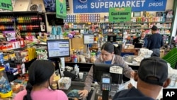 ARCHIVO - La cajera Rosa Dilone ayuda a los clientes en el supermercado Mi Tierra, el 16 de mayo de 2024, en Hazleton, Pensilvania