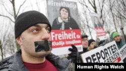 Members of Journalists Without Borders protest against Azerbaijan's President Ilham Aliyev during his visit to meet German Chancellor Angela Merkel, in front of the Chancellery in Berlin, January 21, 2015. REUTERS/Fabrizio Bensch (GERMANY - Tags: POLI