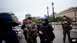 Armed police officers and soldiers patrol after an incident at the police headquarters after in Paris, Oct. 3, 2019. 