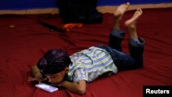 FILE - A young Sikh plays with a smartphone inside a Sikh temple during their Baisakhi festival in Palma de Mallorca on the Spanish Balearic island of Mallorca, April 27, 2014. 