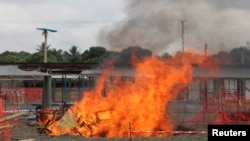 A portion of a Medecins Sans Frontieres (MSF) Ebola treatment unit burns as the MSF begins decommissioning the facility in Monrovia, Liberia, Jan. 26, 2015. 