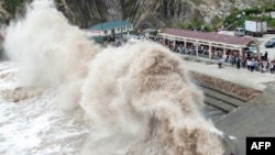People gather to see huge waves as typhoon Chan-hom comes near Wenling, east China's Zhejiang province, July 10, 2015. 