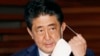 Perdana Menteri Jepang Shinzo Abe melepas masker ketika berbicara dalam sebuah konferensi pers di Tokyo, 21 Mei 2020. (Foto: AP)