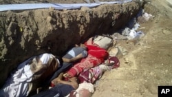 This citizen journalism image provided by Shaam News Network SNN, taken on Sunday, Aug. 26, 2012, purports to show people killed by shabiha, pro-government militiamen, being buried in a mass grave in Daraya, Syria. According to activists' accounts, govern