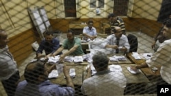 Egyptian elections officials count ballots at a polling center during the second day of the presidential runoff, in Cairo, Egypt, Sunday, June 17, 2012.