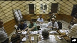 Egyptian elections officials count ballots at a polling center during the second day of the presidential runoff, in Cairo, Egypt, Sunday, June 17, 2012.