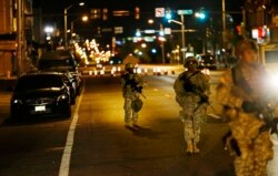 FILE - National Guardsmen walk along North Avenue in Baltimore near where disturbances occurred following the funeral for Freddie Gray, after a 10 p.m. curfew went into effect, April 29, 2015.