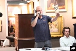 A Brunk auction worker  waits to spot    if a caller wants to marque   a bid during an auction that included a 1787 transcript  of the U.S. Constitution, astatine  Brunk Auctions successful  Asheville, N.C., Oct. 17, 2024.