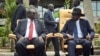 FILE - South Sudan's then First Vice President Riek Machar, left, looks across at President Salva Kiir, right, as they sit to be photographed following the first meeting of a transitional coalition government, in the capital Juba, April 29, 2016. (AP Photo/Jason Patinkin)