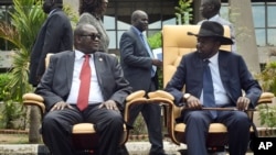 FILE - South Sudan's then First Vice President Riek Machar, left, looks across at President Salva Kiir, right, as they sit to be photographed following the first meeting of a transitional coalition government, in the capital Juba, April 29, 2016. (AP Photo/Jason Patinkin)