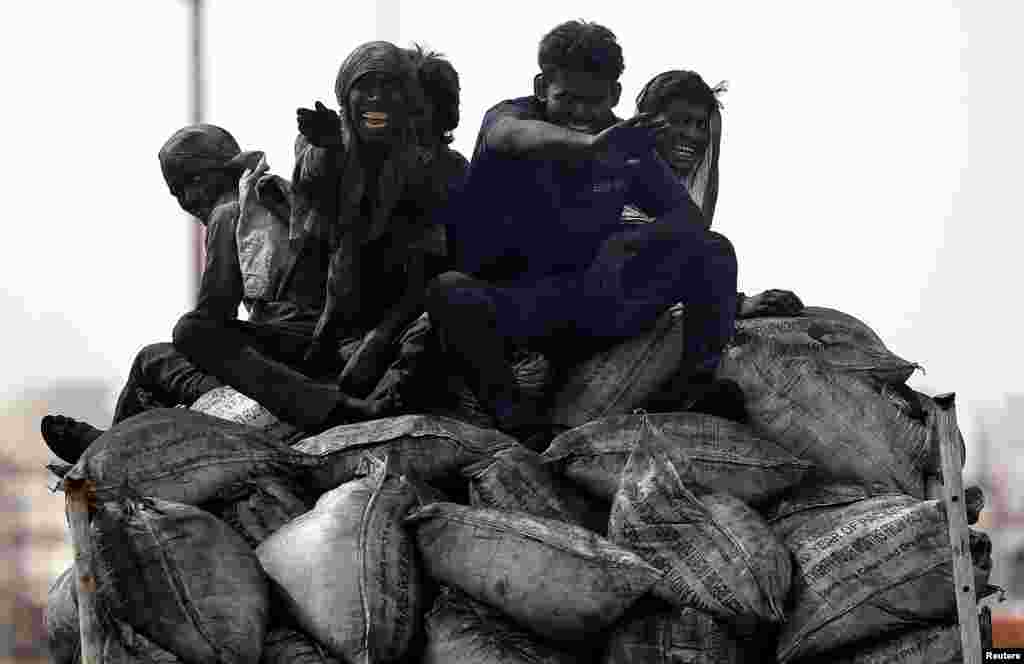 Coal workers travel on the back of a truck in Barsana, India.