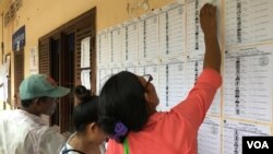 Công dân Campuchia kiểm tra tên trong danh sách cử tri tại điểm bỏ phiếu ở Phnom Penh.
