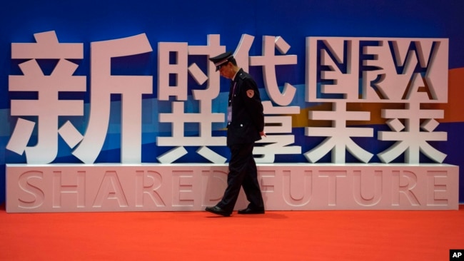 一名警卫在上海中国国际进口博览会的口号前走过。（2018年11月5日）