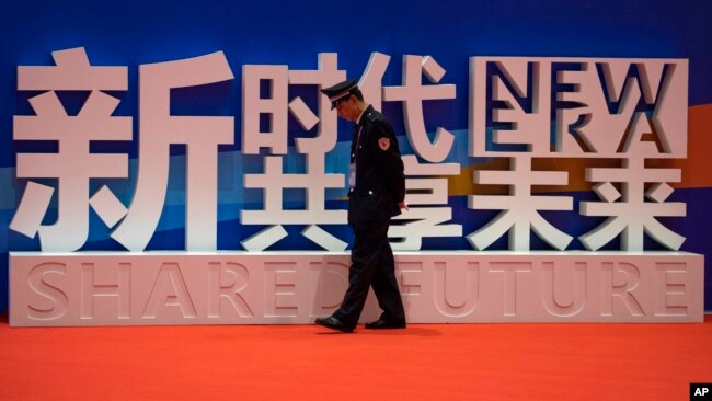 一名警卫在上海中国国际进口博览会的口号前走过。(2018年11月5日)