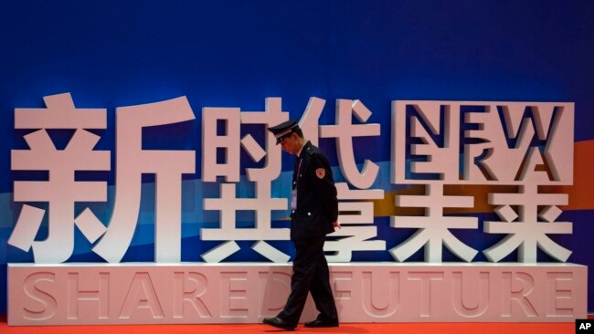 一名保安在上海中国国际进口博览会的口号前走过。(2018年11月5日)