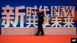 一名警卫在上海中国国际进口博览会的口号前走过。（2018年11月5日）