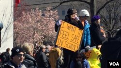 Demonstrators hold signs at the anti-gun violence rally in Washington, March 24, 2018. (E. Sarai/VOA)