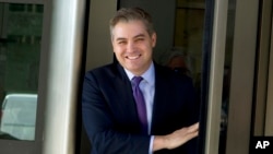 CNN's Jim Acosta walks out of the U.S. District Courthouse with a smile, Nov. 16, 2018, in Washington. 