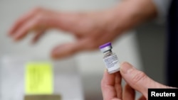 Seorang perawat memegang botol vaksin Pfizer-BioNTech COVID-19 di pusat vaksinasi penyakit coronavirus. (Foto: Reuters)