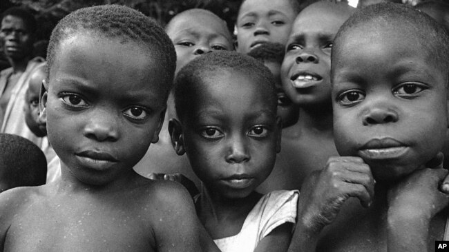 FILE - A group of starving Biafran children wait at Aba for doctors to see them, July 27, 1968.