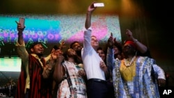 French President Emmanuel Macron, center, takes a selfie with Nigeria Nollywood Actors during an event to celebrate African Culture at the New Afrika shrine in Lagos, July 3, 2018. 