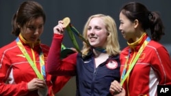 L’américaine Virginia Thrasher (C) présente sa médaille d'or de tir à la carabine 10 m remportée devant Du li de la Chine –argent- (G), et Yi Siling (D) de la Chine également –bronze- aux JO 2016 à Rio de Janeiro, au Brésil, le 6 août 2016. 