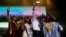 French President Emmanuel Macron, center, takes a selfie with Nigeria Nollywood Actors during an event to celebrate African Culture at the New Afrika shrine in Lagos, July 3, 2018. 