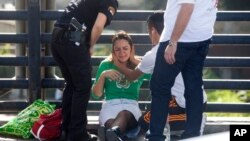 Paramedics treat a woman for shock after a soldier was stabbed in Tel Aviv, Israel, Nov. 10, 2014. 