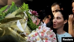 Yoani Sánchez recibe flores en una conferencia en Sao Paulo. En Miami recibirá condecoraciones por su valenteía.