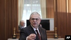 Greek Prime Minister Lucas Papademos welcomes members of Hellenic Confederation of Professionals, Craftsmen and Merchants during a meeting in Athens, January 4, 2012.