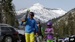 Bret McTigue, left, and his daughter Taylor, 8, head to the slopes at Sierra-at-Tahoe Ski Resort in Echo Summit, California, Jan. 3, 2018. Researchers on Thursday found that the snowpack in the area stood at less than a third of its normal size for the date.