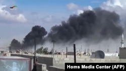 Smoke billows from buildings in the central Syrian town of Talbisseh in Homs province. Russian warplanes carried out airstrikes in three Syrian provinces, including Homs, along with regime aircraft, according to a Syrian security source, Sept. 30, 2015.